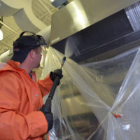 HOODZ franchise HOODZ technician spraying a kitchen hood